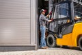 Forklift Driver Loading Fork Truck Into Warehouse