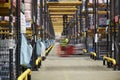 Forklift driving across an aisle in a warehouse, motion blur Royalty Free Stock Photo