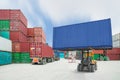 Forklift handling container box loading to truck in import expo