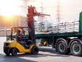 Forklift handling white sugar bags outside warehouse for stuffing onto truck. Royalty Free Stock Photo