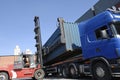Forklift hoisting cargo and shipping containers