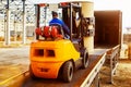 Forklift is putting cargo from warehouse to truck Royalty Free Stock Photo