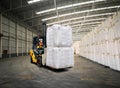 Forklift stack jumbo bags of sugar, rice, grain inside a warehouse. Cargo in jumbo bag handling and storage.