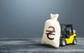 Forklift transports a ukrainian hryvnia money bag. Investing in economy. Economic support, lending. Crisis recovery measures. Royalty Free Stock Photo