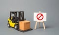 Forklift truck carries a cardboard box near a stand with a red symbol NO. No delivery. Restriction on the importation of goods Royalty Free Stock Photo