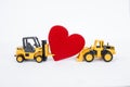 Forklift truck and front loader truck moving red heart