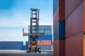 Forklift truck lifting cargo container in shipping yard or dock yard against sunrise sky for transportation import, Export and log Royalty Free Stock Photo