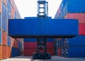 Forklift truck lifting cargo container in shipping yard or dock yard against sunrise sky for transportation import Royalty Free Stock Photo