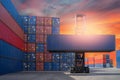 Forklift truck lifting cargo container in shipping yard or dock yard against sunrise sky for transportation import Royalty Free Stock Photo