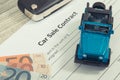 Form of car sale agreement, euro baknotes, blue toy car and key. Sales and purchases new or used vehicle Royalty Free Stock Photo