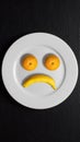 In the form of a disgruntled face, tangerines and a banana on a plate. Fruit imitating a sad smiley Royalty Free Stock Photo