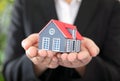 Formal dress women holding small house model