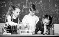 Formal education. Girls and boy student conduct school experiment with liquids. School laboratory. Group school pupils