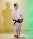 Formal exercises on a colored background with yellow and green tints being trained by a man with a black belt