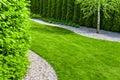 Formal garden with a path of small stones, hedgerow and green lawn Royalty Free Stock Photo