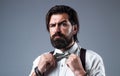 Formal man wear suspenders and fix bow tie has well groomed hair and beard, fashion and barbershop
