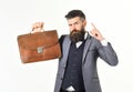 Formal outfit concept. Bearded man wears formal outfit and holds vintage case.