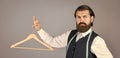 formal stylish mens clothing on hanger stand in room. tailor man holds in his hand a hanger. Handsome man in formal vest