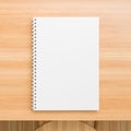 A4 format spiral binding notebook mock up on wooden table. Realistic notebook mock up. 3D illustration