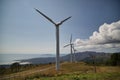 Formation of several wind turbines placed on a mountain facing the ocean. Concept renewable energy, electricity, environment,