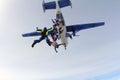 Formation skydiving. Skydivers are jumping out of an airplane into the sky.