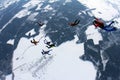 Formation skydiving in the winter sky above snowy fields.