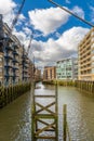 Former historic warehouses now converted into housing lining the River Thames like a canal with green mud and moss from the low Royalty Free Stock Photo