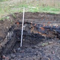 Former rubbish dump in the excavation pit, black discoloured and Royalty Free Stock Photo