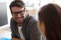 Forming positive workplace relationships. Shot of a young designer smiling positively while conversing with a colleague.