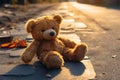 A forsaken teddy bear rests on the street, yearning for reunion