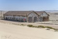 forsaken warehouse buildings on sand at mining ghost town in desert, Kolmanskop, Namibia