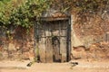 An ancient rustic wooden door on an old, laterite brick wall in the heritage town of Royalty Free Stock Photo