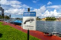 Warning sign watch for Manatees at the pier in Fort Lauderdale with tropical skyline