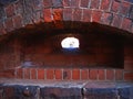 FORT WINDOW OPENING IN A THICK STONE WALL FRAMED WITH BRICKS Royalty Free Stock Photo