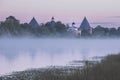 Fortress in the city of Staraya Ladoga on the Volkhov River with a foggy pink summer dawn