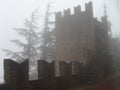 Fortress in San Marino in foggy weather. Ancient stone walls with checkers. Thick fog and rain Royalty Free Stock Photo