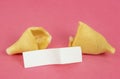 Fortune Cookie on a crimson background. Close-up of foreboding broken cookies with white piece of paper with copy space on a dark Royalty Free Stock Photo