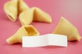 Fortune Cookie on a crimson background. Close-up of foreboding broken cookies with white piece of paper with copy space on a dark Royalty Free Stock Photo