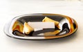 Fortune cookie lies on a black plate on a light background with a blank note Royalty Free Stock Photo