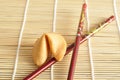 A fortune cookie with red chopsticks Royalty Free Stock Photo