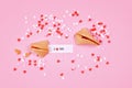 Fortune cookies with text `I love you` and sugar sprinkle hearts on pink background Royalty Free Stock Photo