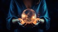 Fortune teller hands. Magic ball in women hands. Blurred dark background