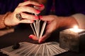 Fortune teller hands shuffling tarot cards. Close-up, moody atmosphere Royalty Free Stock Photo