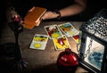 The fortune teller lays out on a wooden table the tarot cards by the light of a lantern and a candle. Royalty Free Stock Photo