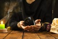 Fortune teller or oracle with a black cup in hand for fortune telling on the coffee grounds. Psychic readings and the concept of