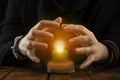 A fortune-teller or oracle with objects for fortune-telling holds a burning candle during the session. Psychic readings and the