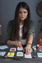 Fortune teller predicting future on spread of tarot cards at grey table indoors Royalty Free Stock Photo