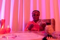 African american plump fortune-teller in ethnic adornments doing Tarot reading