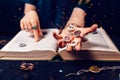 Fortune teller& x27;s hand holds the sparkling zodiac stones in the palm of her hand over the open book. The concept of