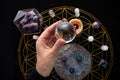 Fortune Telling Table with esoteric objects and hand holding crystal ball. Royalty Free Stock Photo